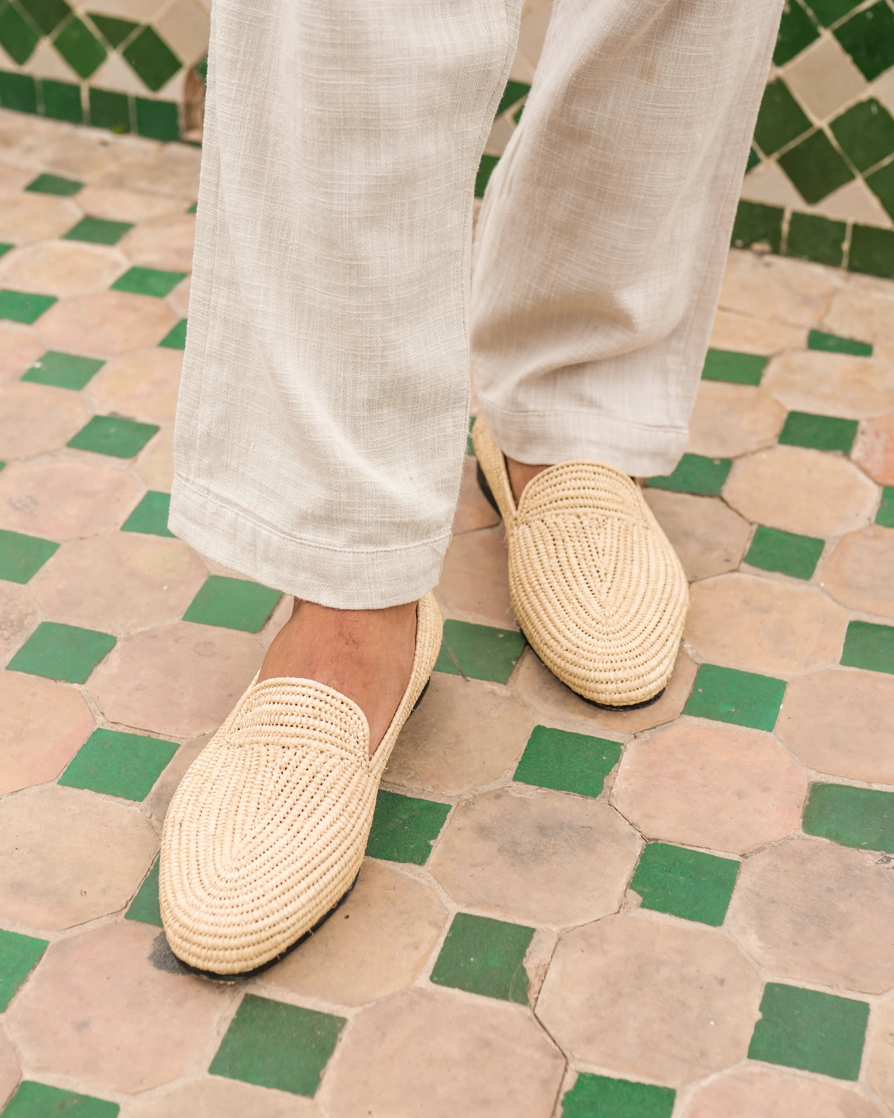 Person wearing beige woven shoes on a patterned floor
