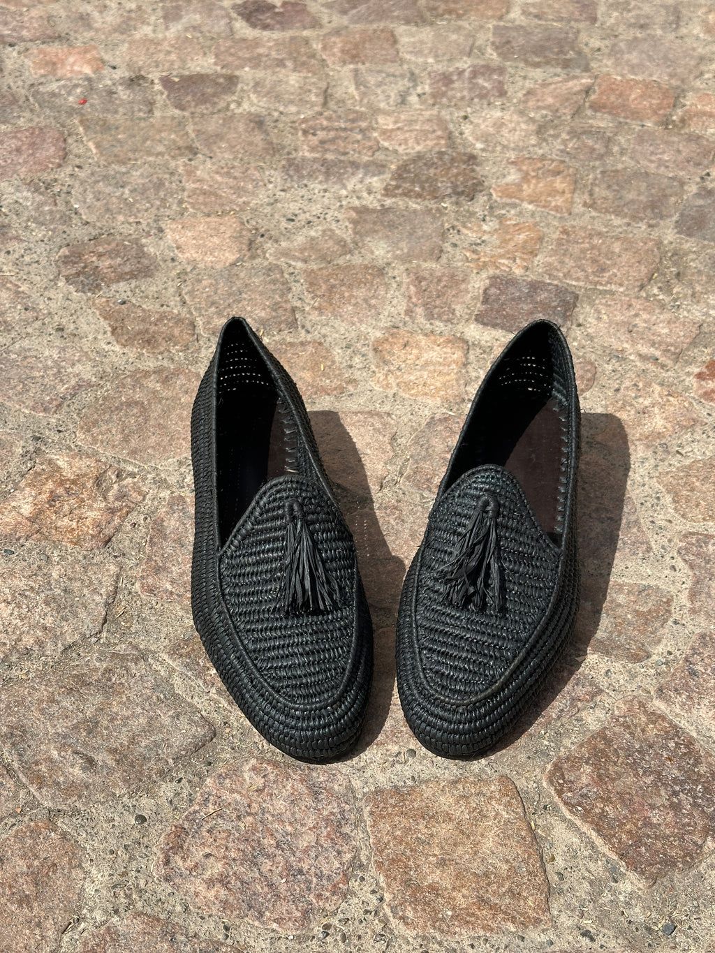 Black slippers on a stone surface