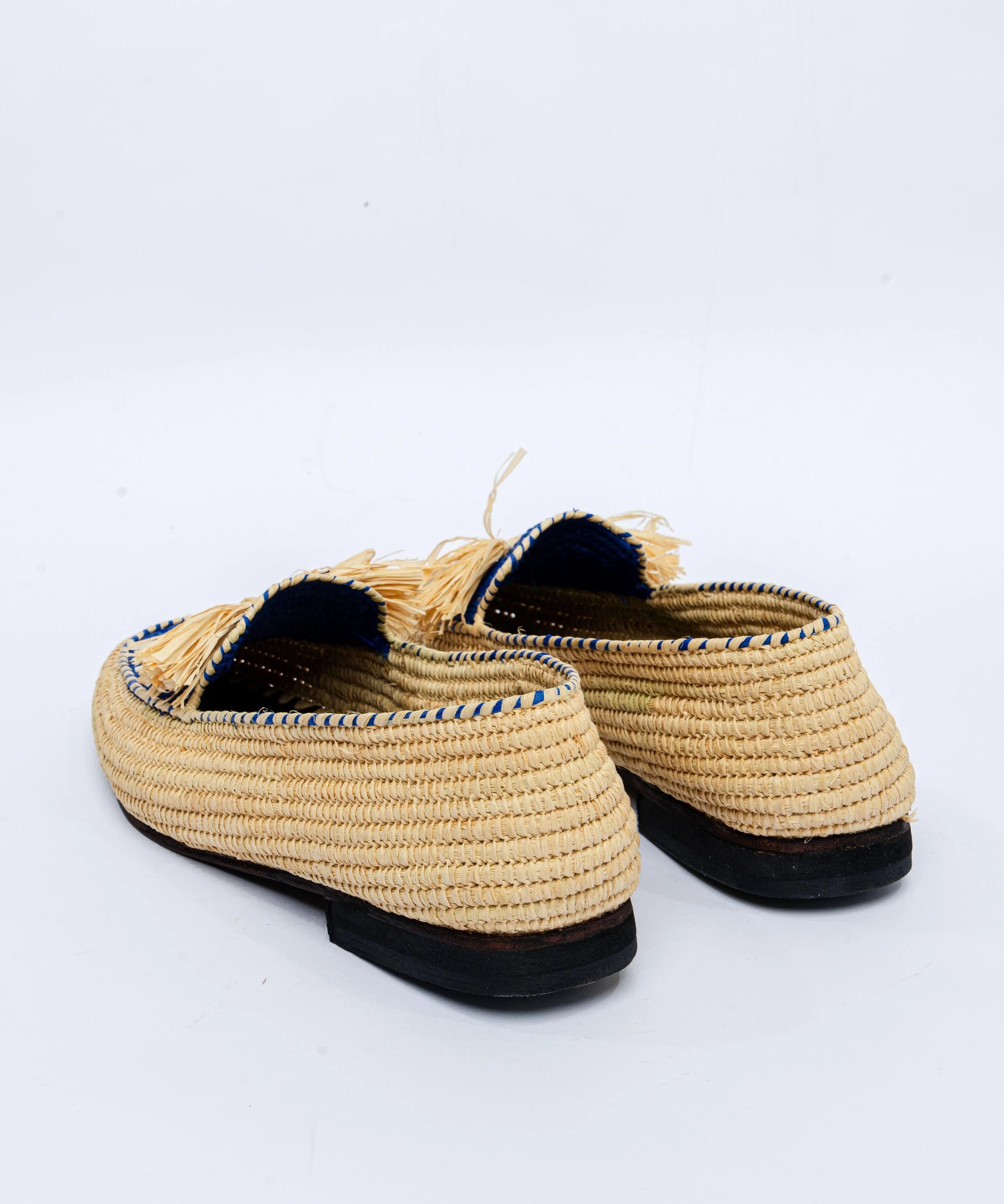 Pair of woven shoes with tassels on a white background