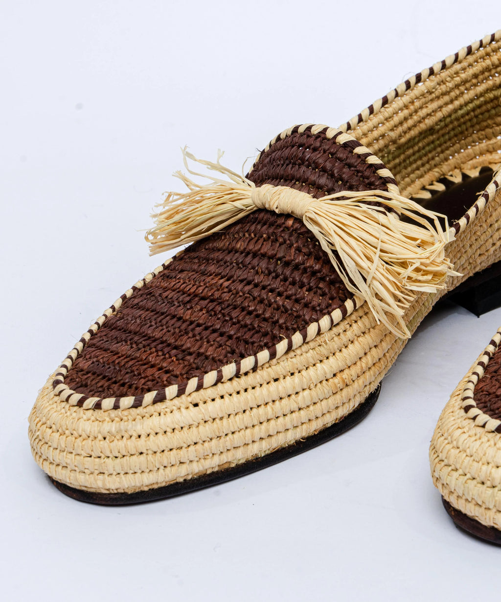 Woven shoe with frayed edge on a light gray background