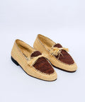 Pair of woven shoes with fringes on a light gray background