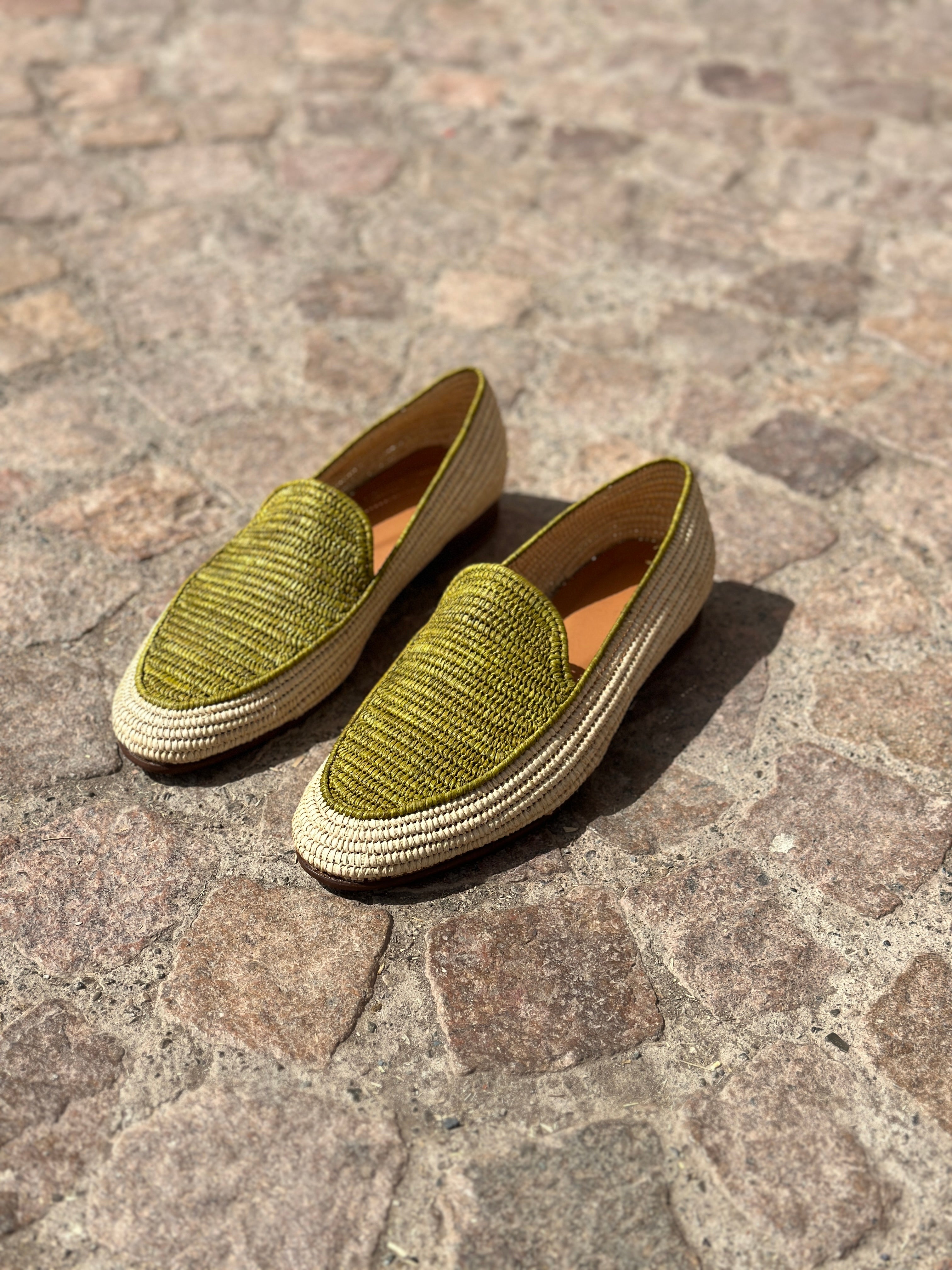 Pair of green loafers on a stone pavement