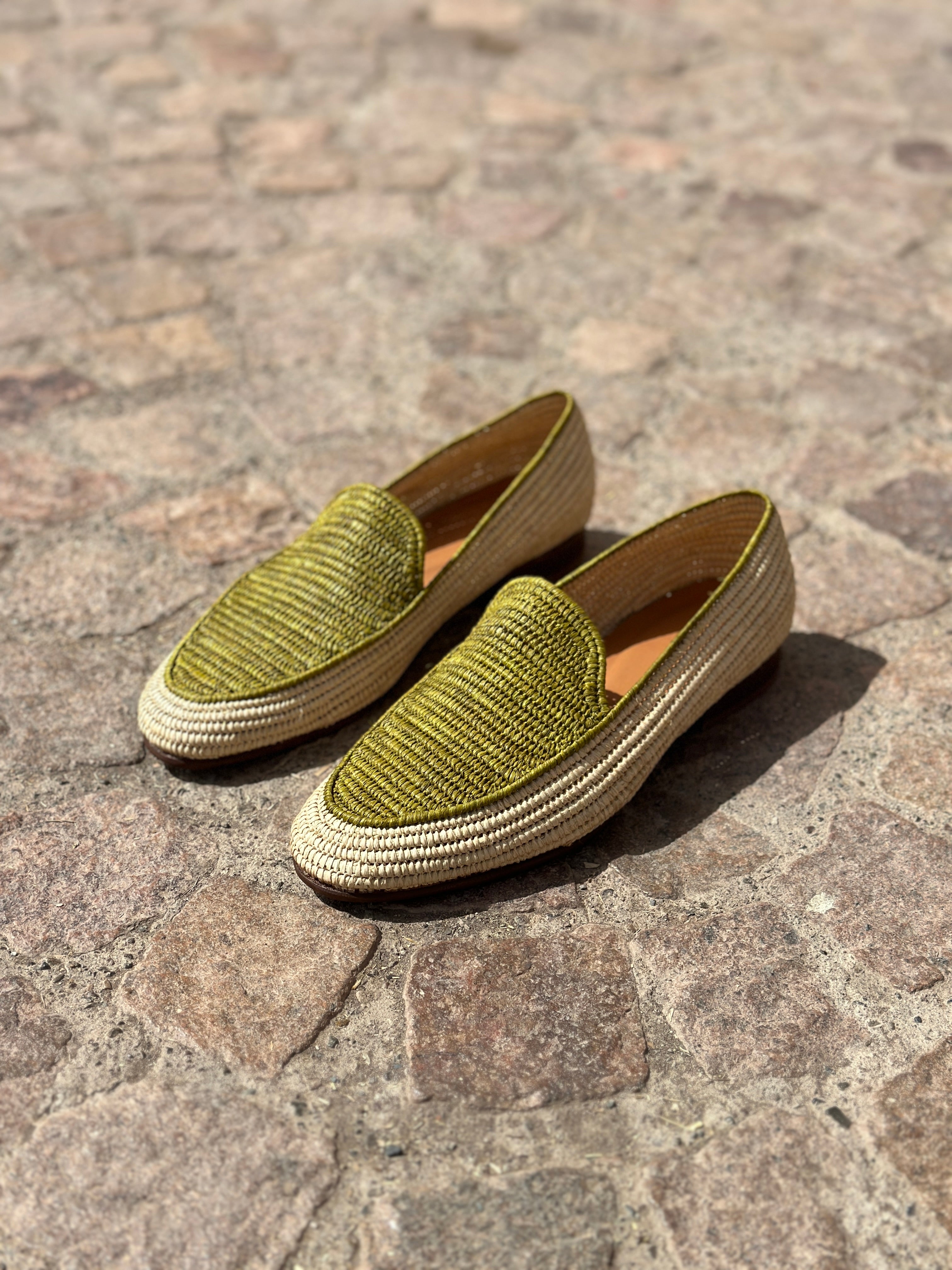 Pair of green loafers on a stone pavement