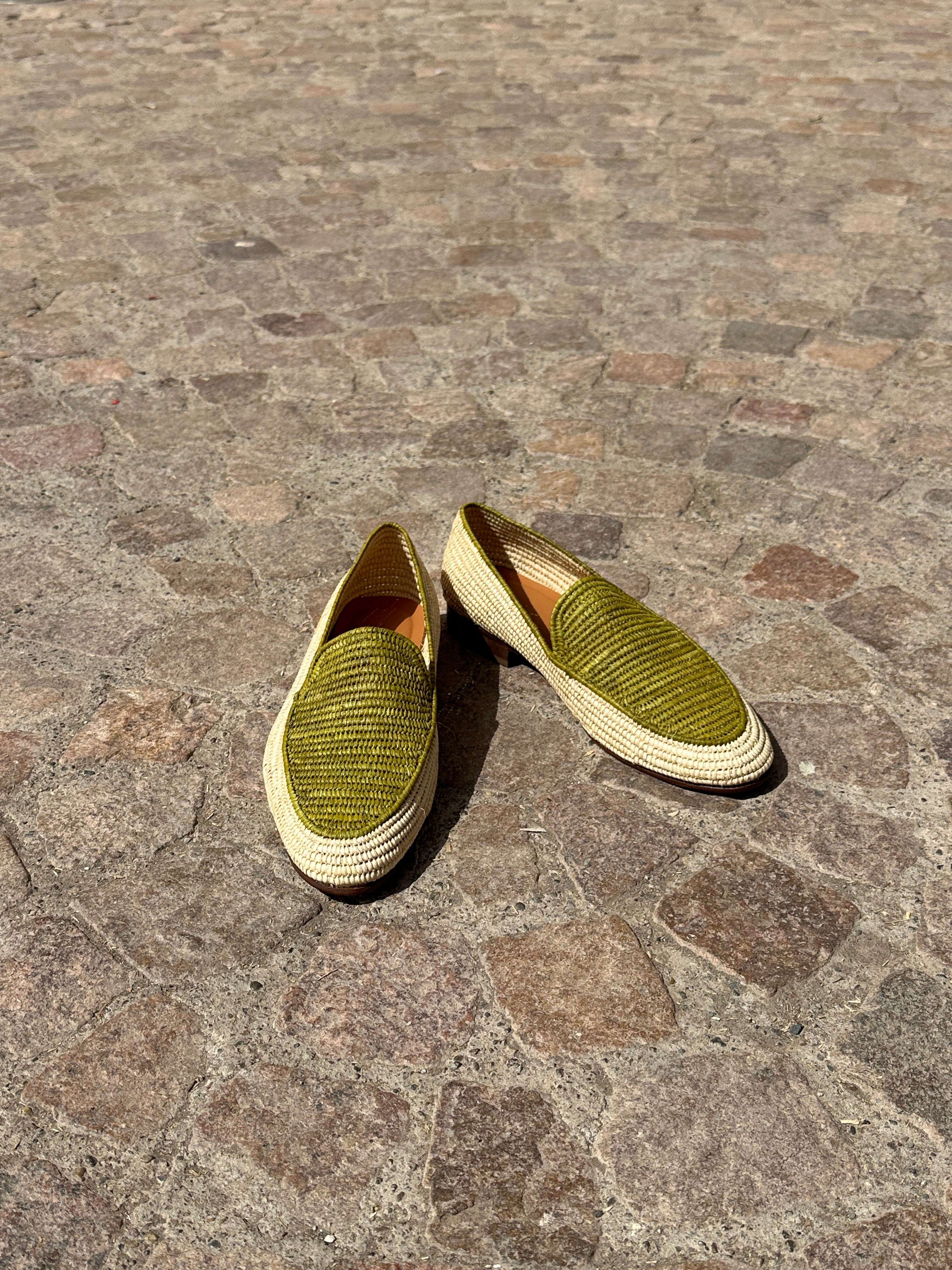 Pair of green shoes on a stone pavement