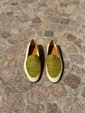 Pair of green loafers on a stone pavement
