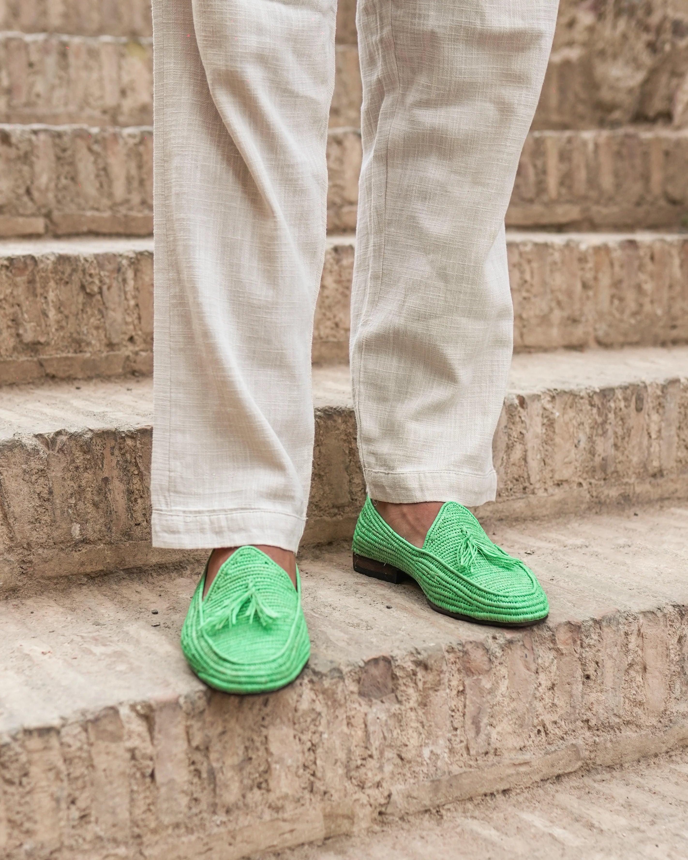 Person wearing bright grass green loafers on stone steps