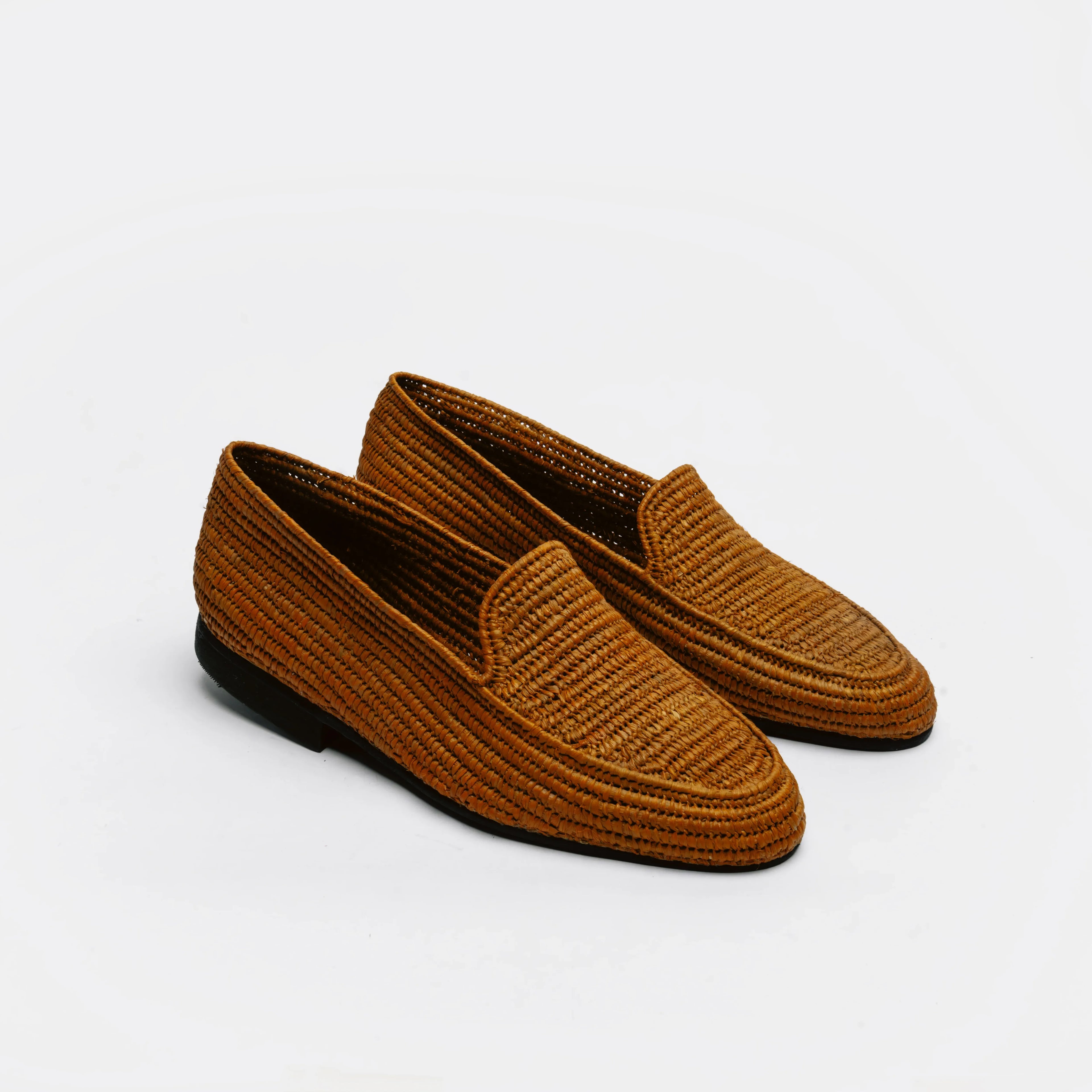 A pair of brown woven slip-on loafers with black soles, photographed on a clean white background.