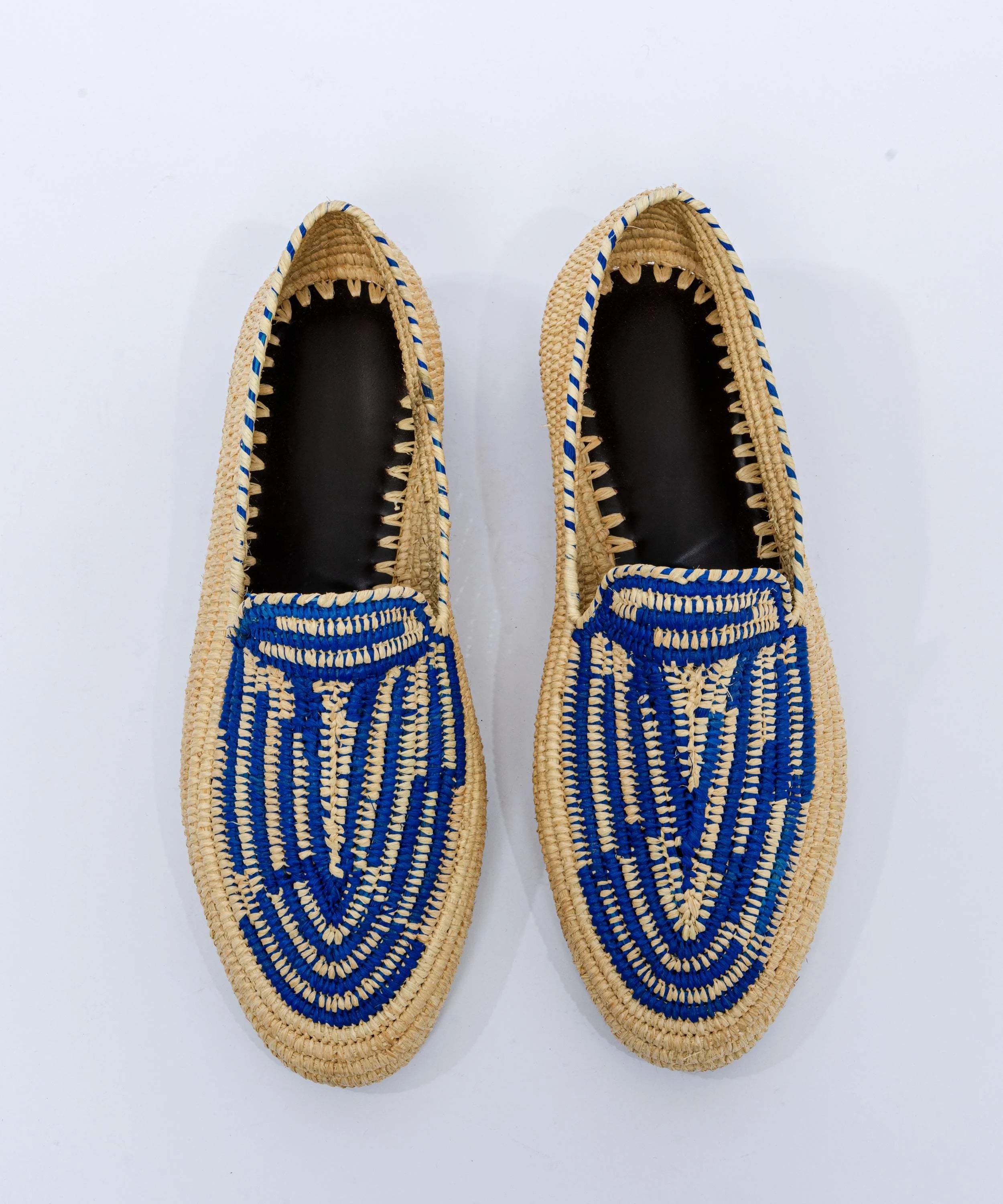 Pair of woven shoes with blue patterns on a white background