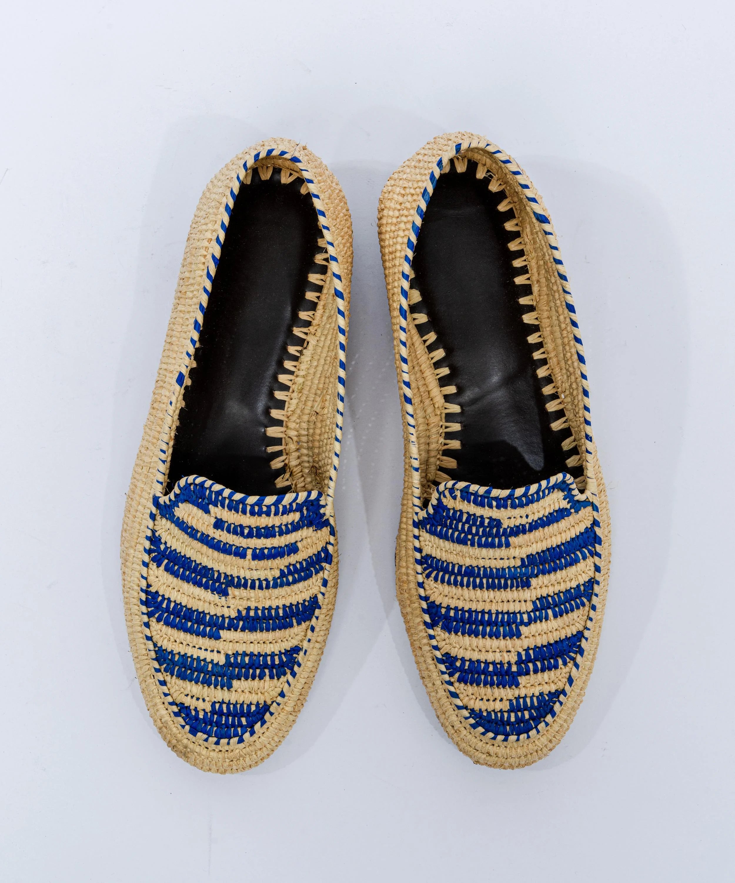 Pair of woven shoes with blue accents on a white background