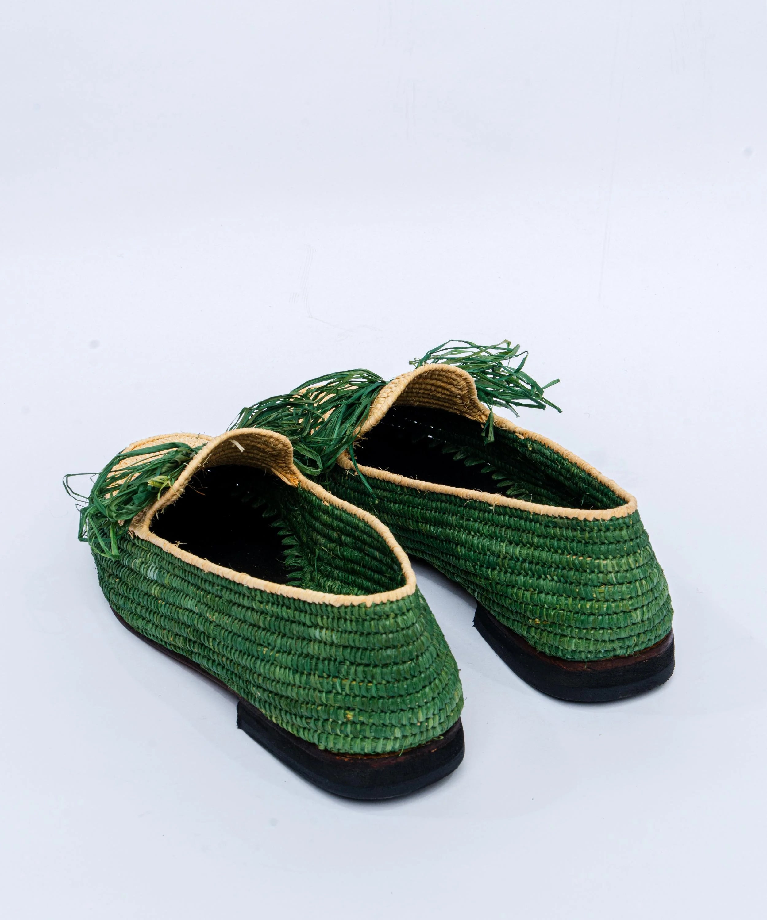 Green woven shoes on a light gray background