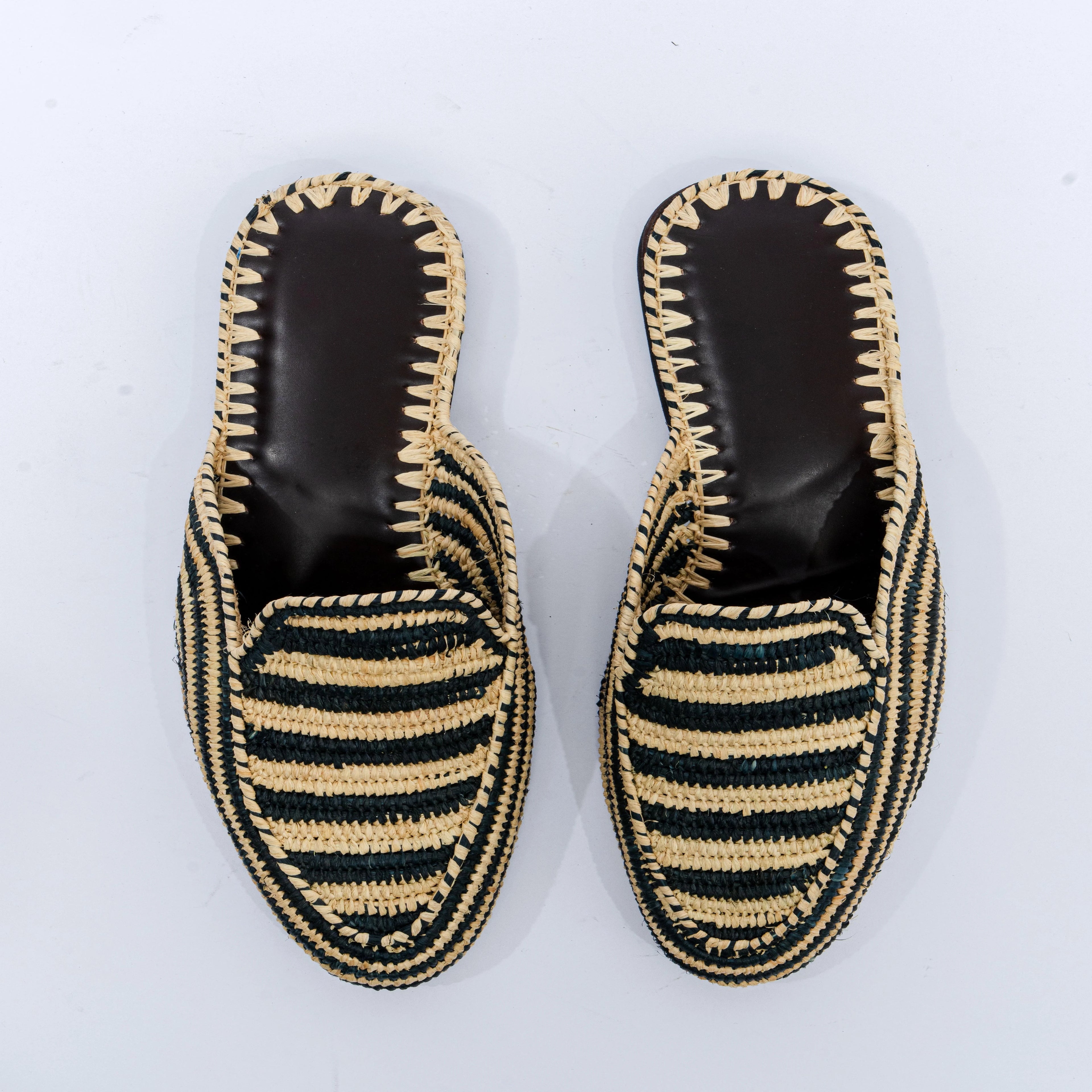 Pair of black and beige striped espadrille shoes on a white background