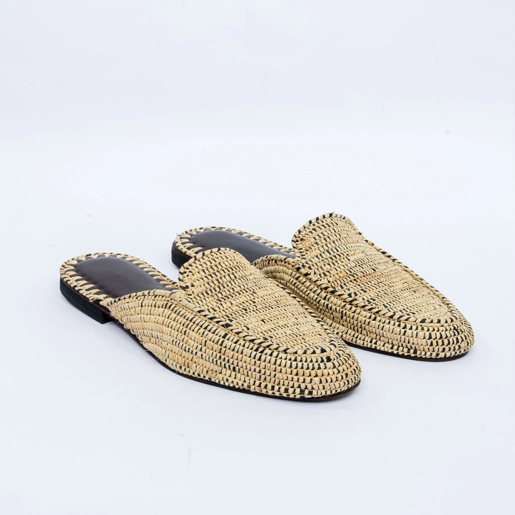 Pair of woven slippers on a light gray background