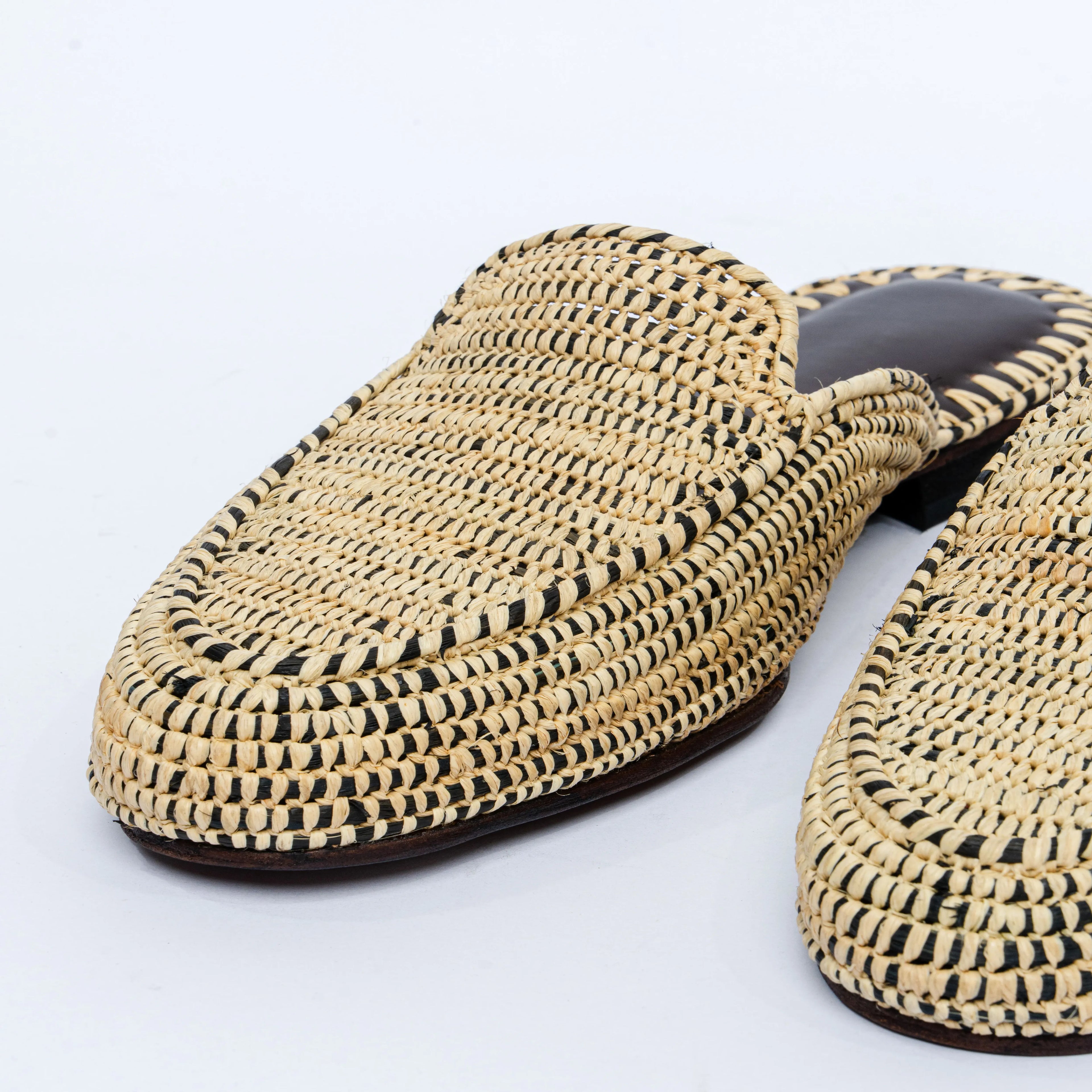 Pair of woven slippers on a light gray background