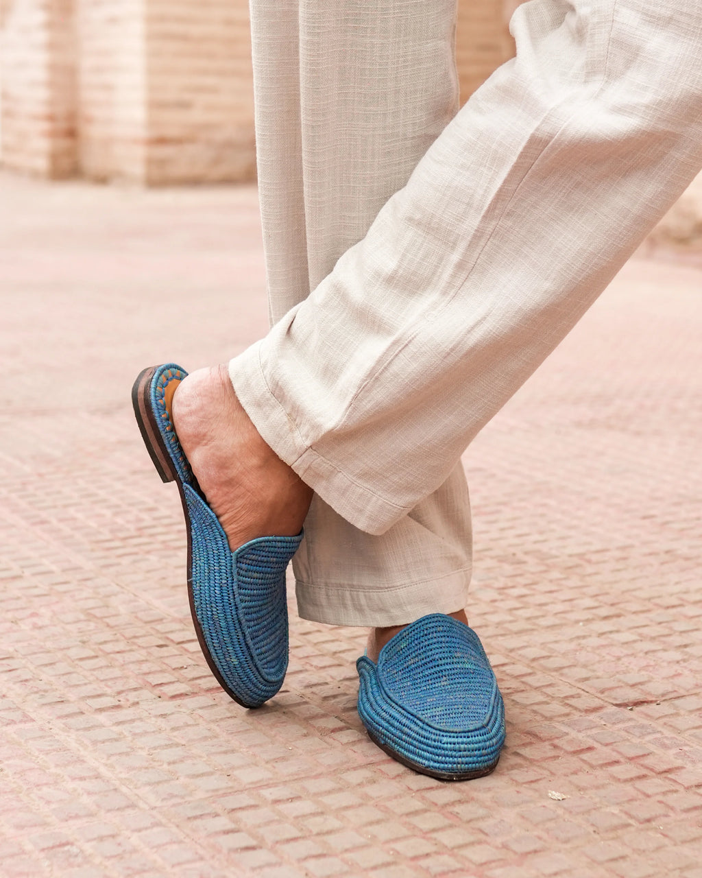 Person wearing blue slippers on a textured surface