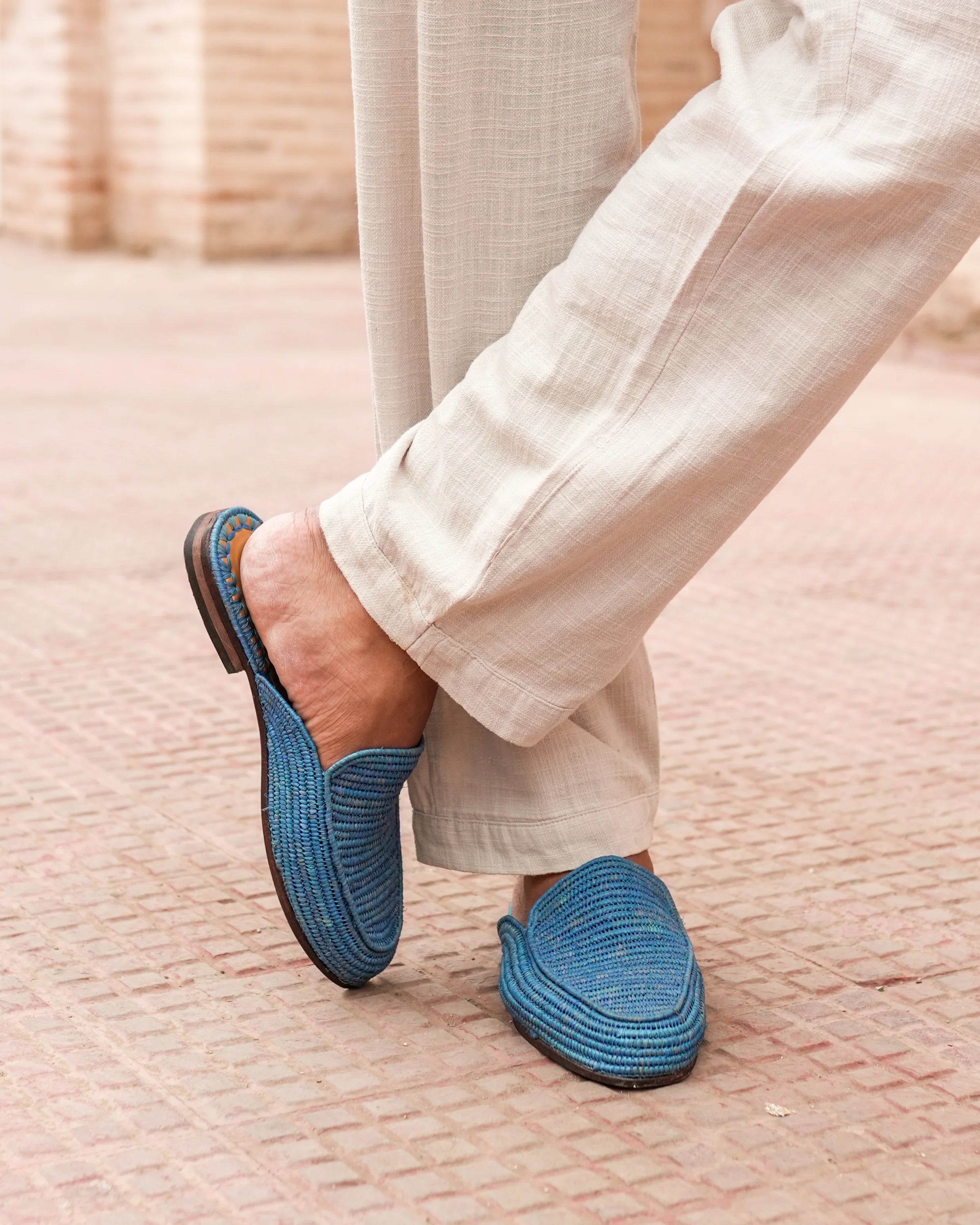 Person wearing blue slippers on a textured surface