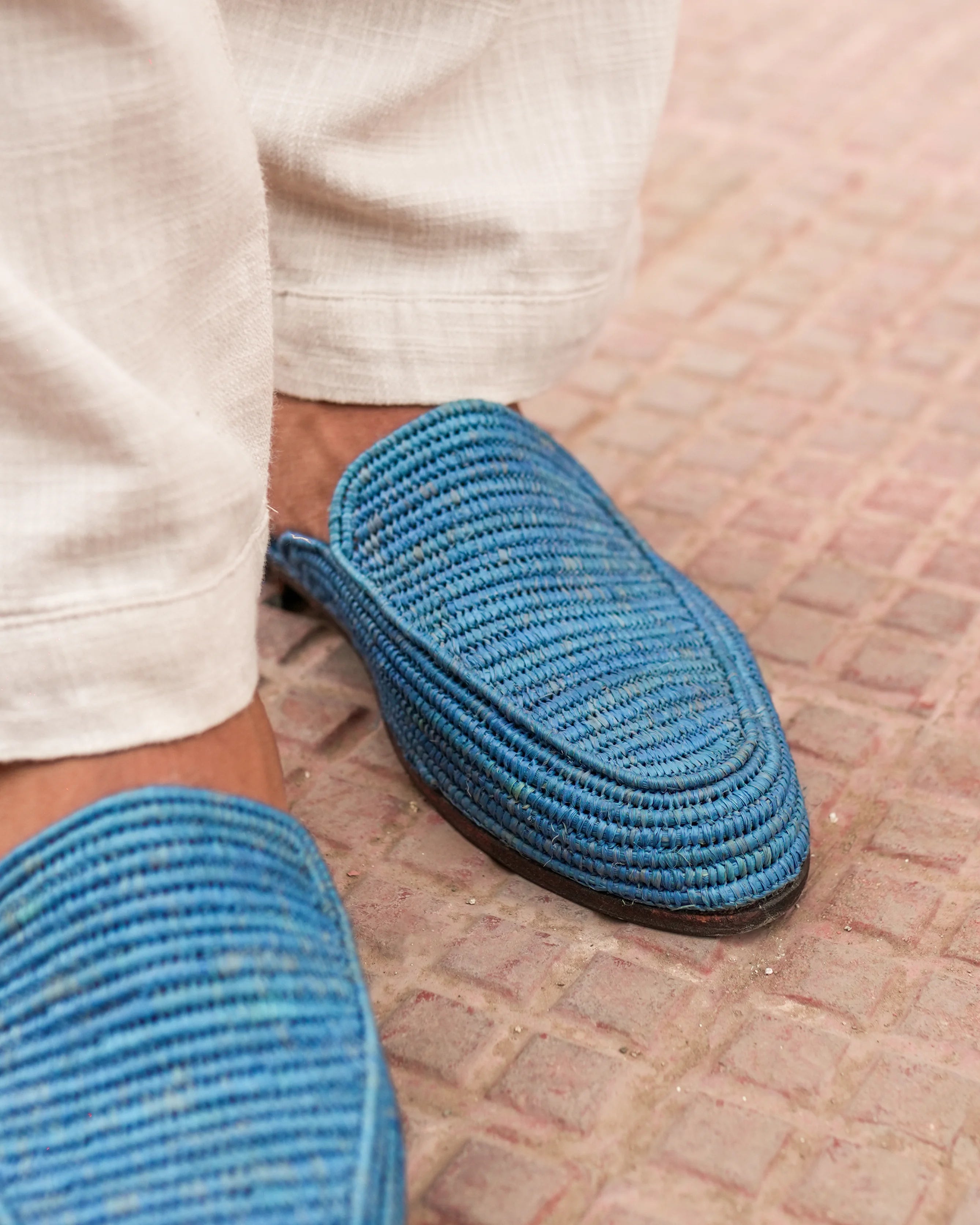 Blue slippers worn on a textured floor
