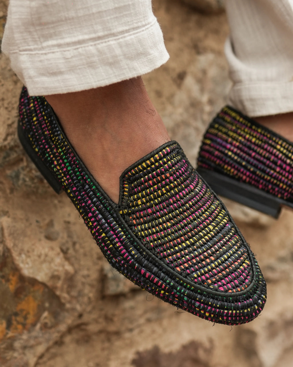 Multicolored woven shoes on a textured surface