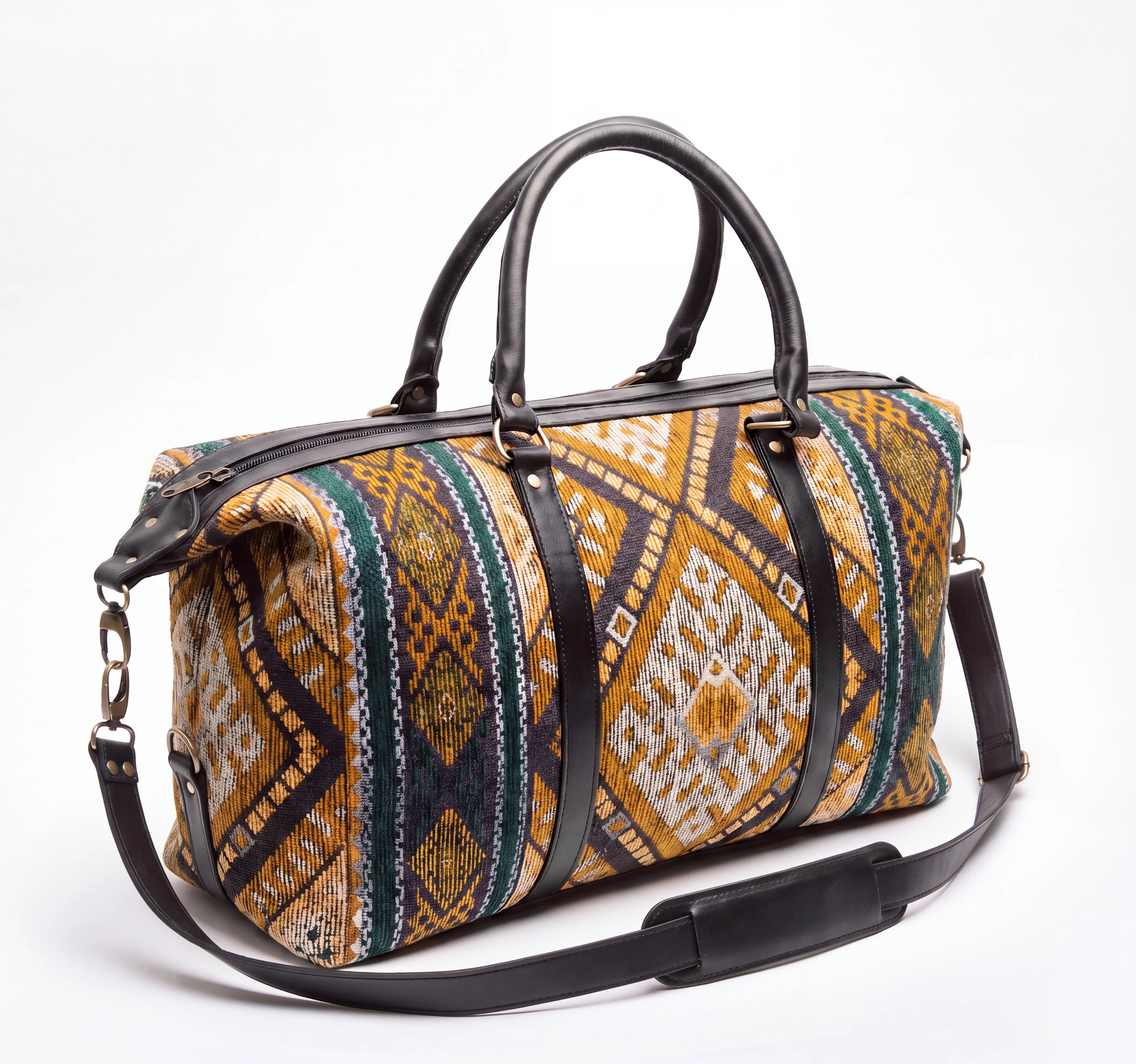 A duffel bag with a colorful geometric patterned fabric body and black leather handles, trim, and adjustable shoulder strap, photographed on a clean white background.