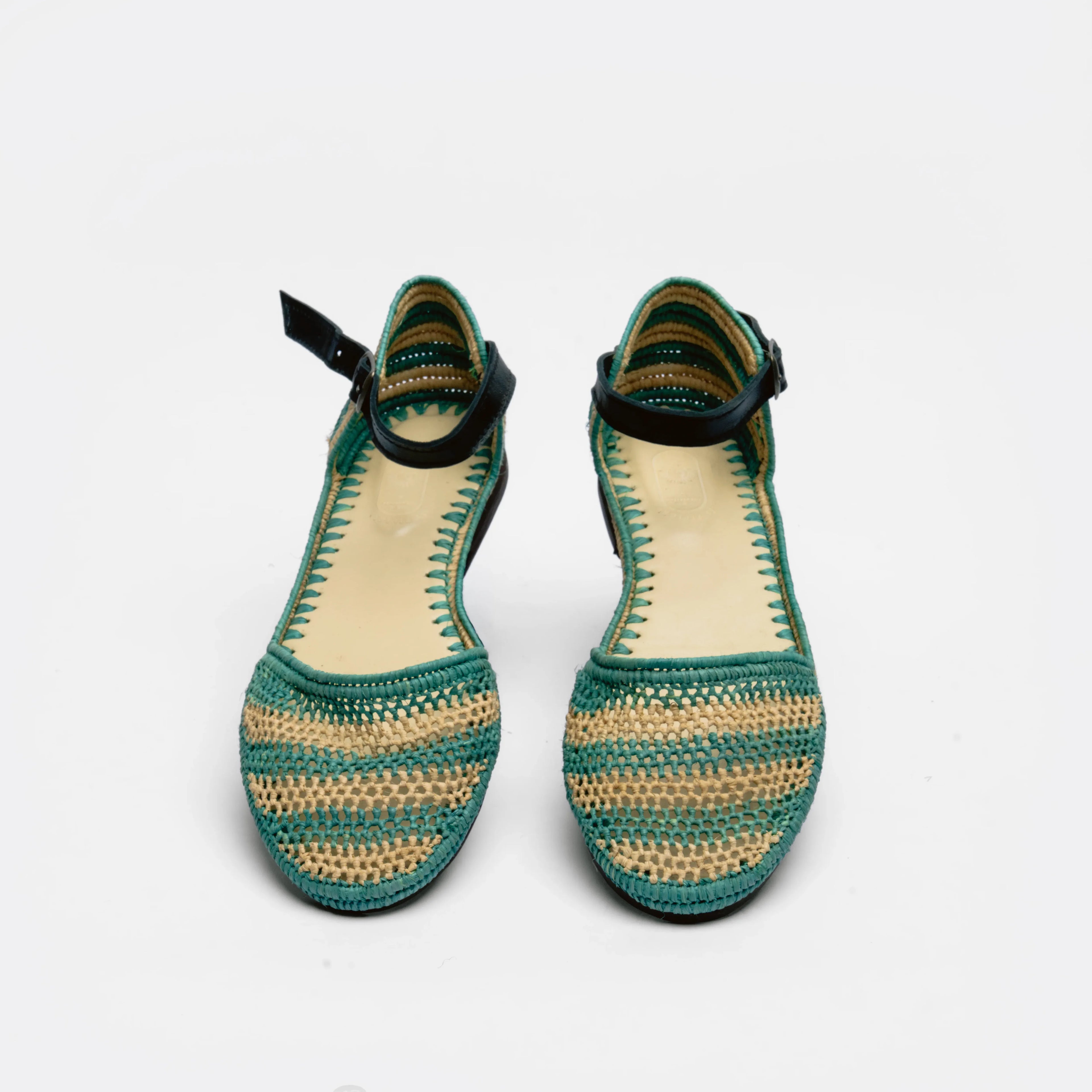 A pair of women's crochet flat sandals with a green and beige woven pattern, black ankle straps, and a light beige insole, shown against a plain white background.