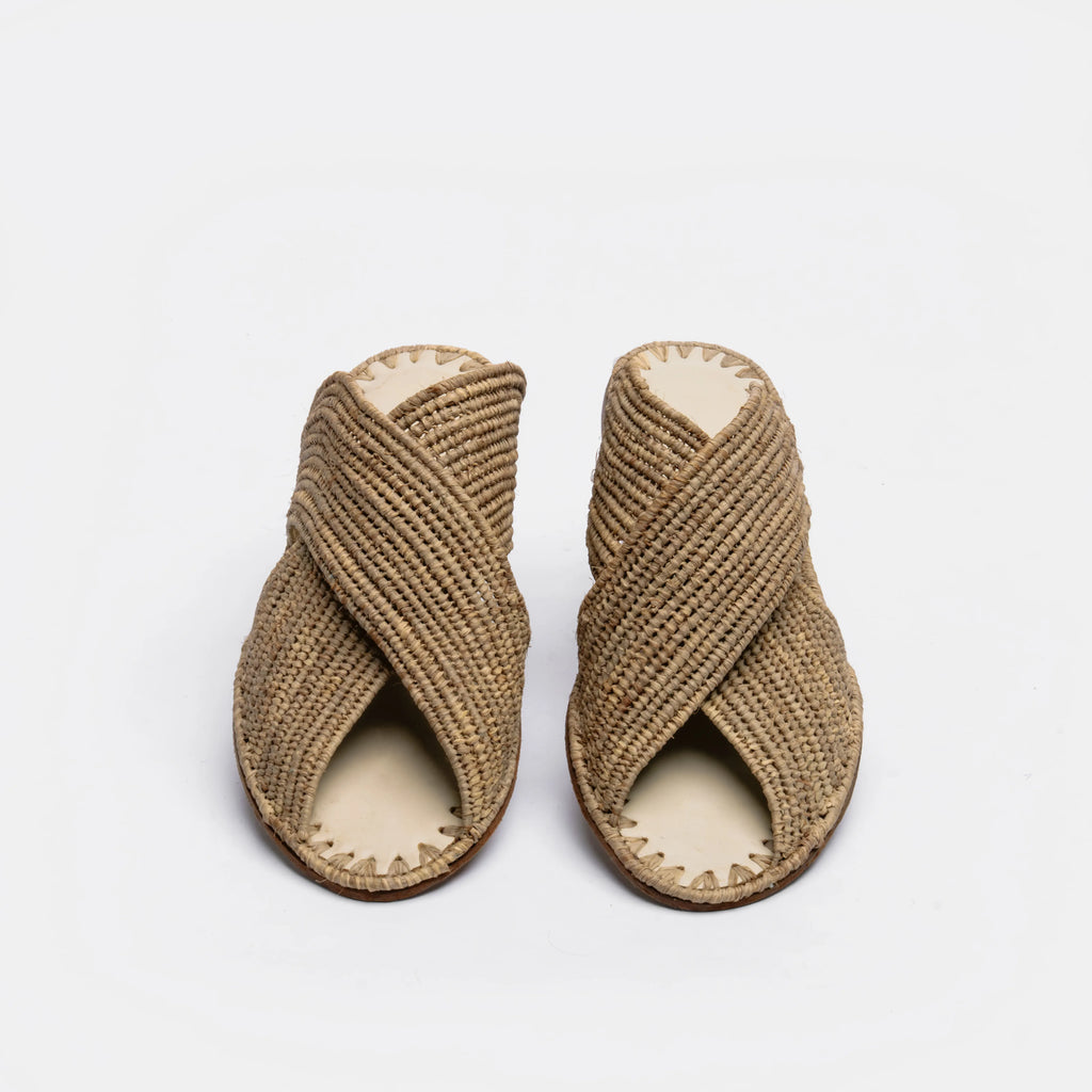 A pair of woven straw sandals with crisscrossed straps and open toes, shown on a plain white background.