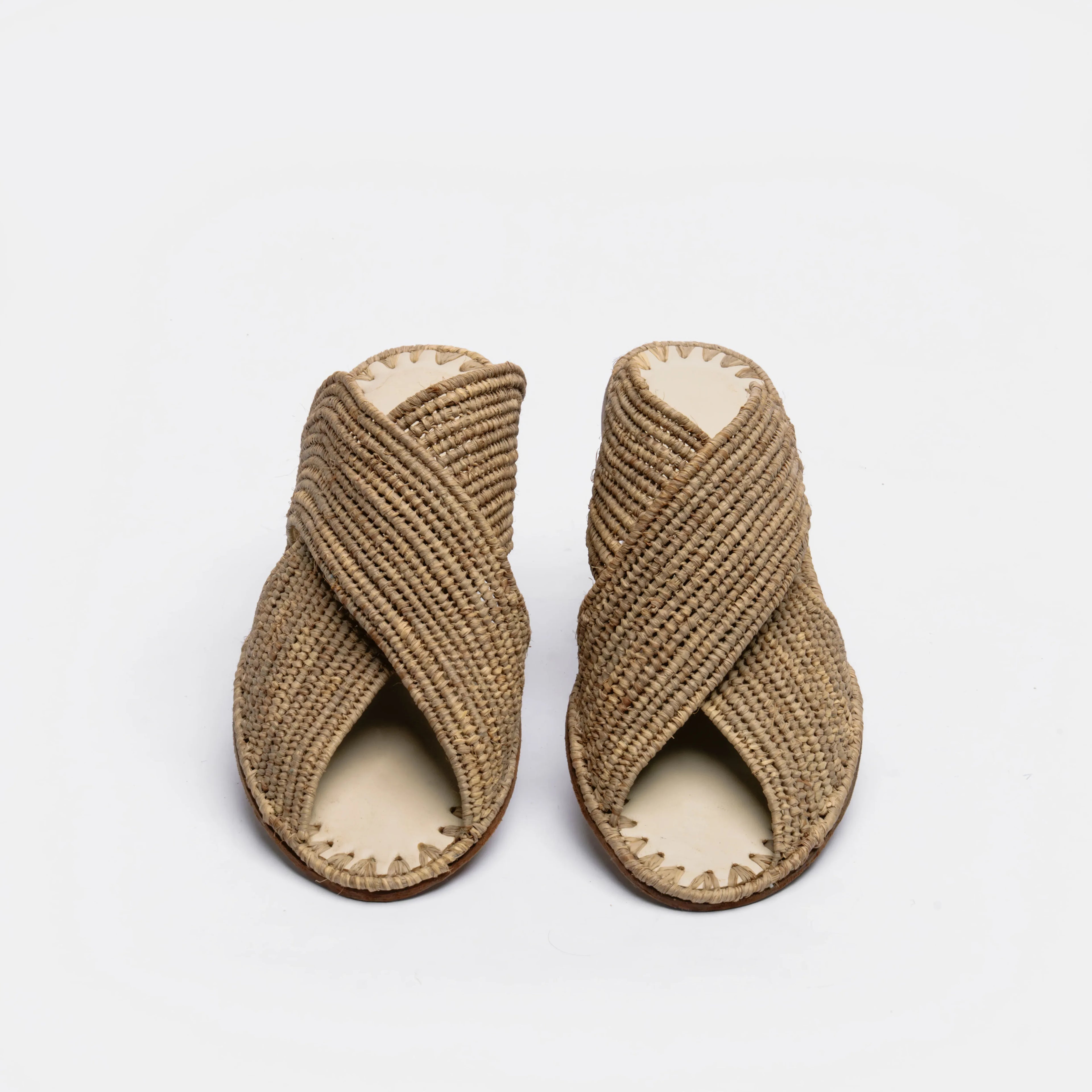 A pair of woven straw sandals with crisscrossed straps and open toes, shown on a plain white background.